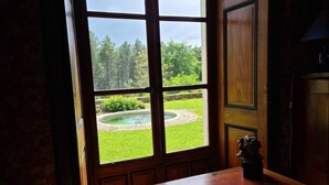 Una habitación con un ventanal grande, una mesa de madera y una pequeña estatua sobre la mesa.