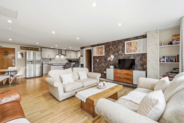 A modern living room with a sofa set, a coffee table, and a TV.