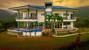 Un immeuble de deux étages doté d’une piscine, de balcons et offrant une vue sur les montagnes.