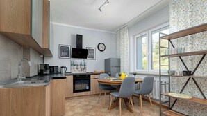 Eine moderne Küche mit Holzausziehtüren, einem eingebauten Backofen und einem Essbereich mit Tisch und Stühlen.