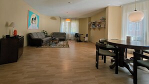 Un salon avec un canapé, une table basse et une table à manger.
