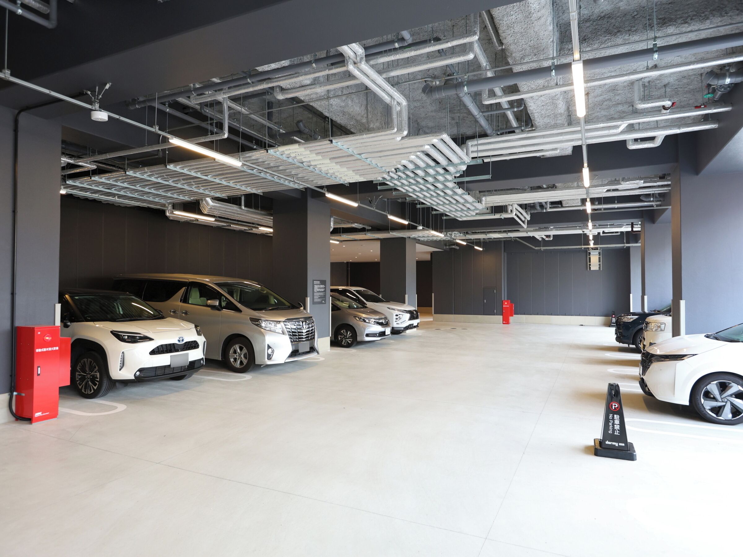 Eine mehrgeschossige Parkgarage mit mehreren Autos, freiliegenden Leitungen und einem klaren, modernen Design.