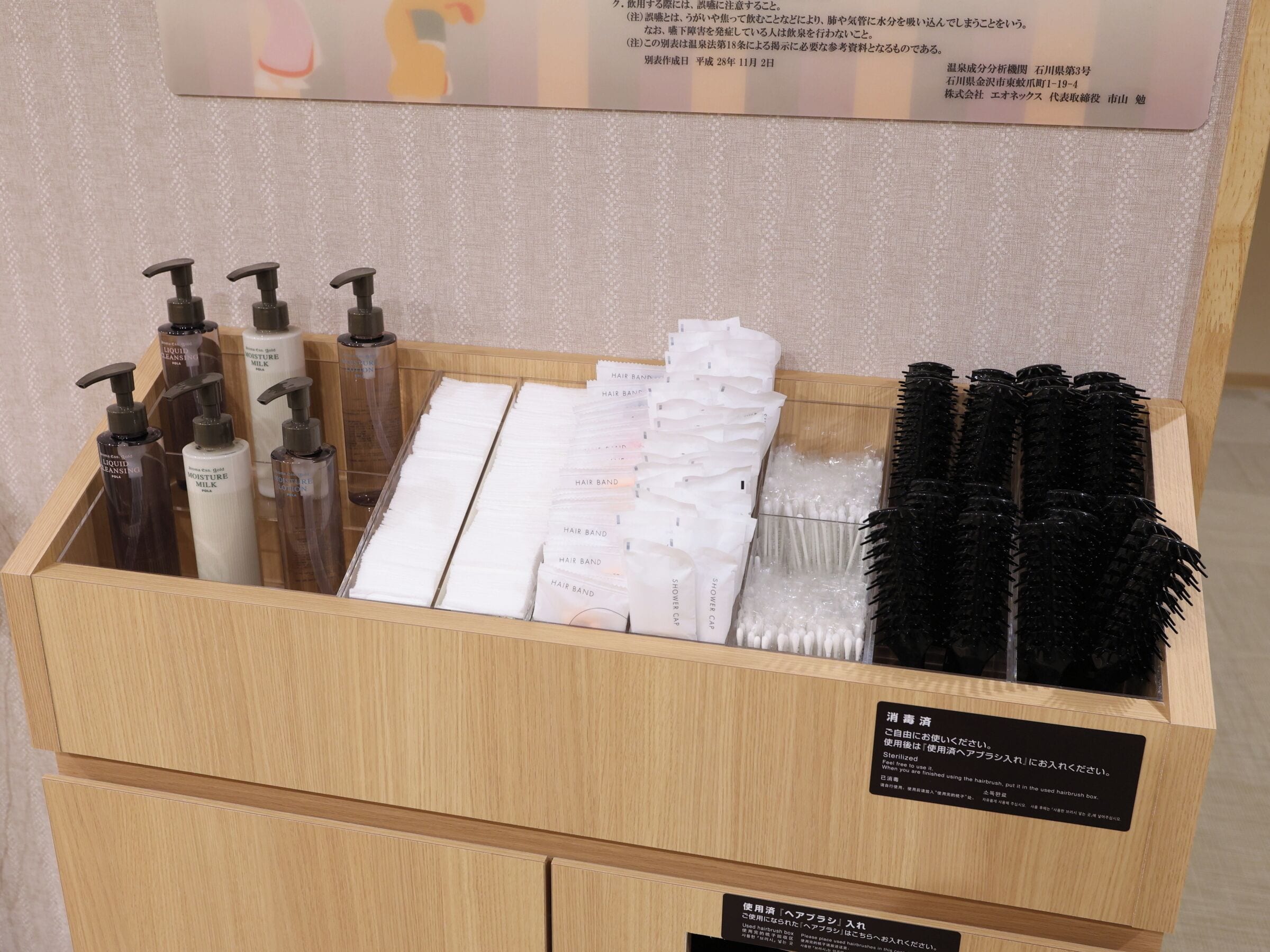 A wooden box containing hair care products, including shampoos, conditioners, and hairbrushes.