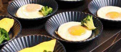 A series of bowls with eggs and broccoli on a countertop.