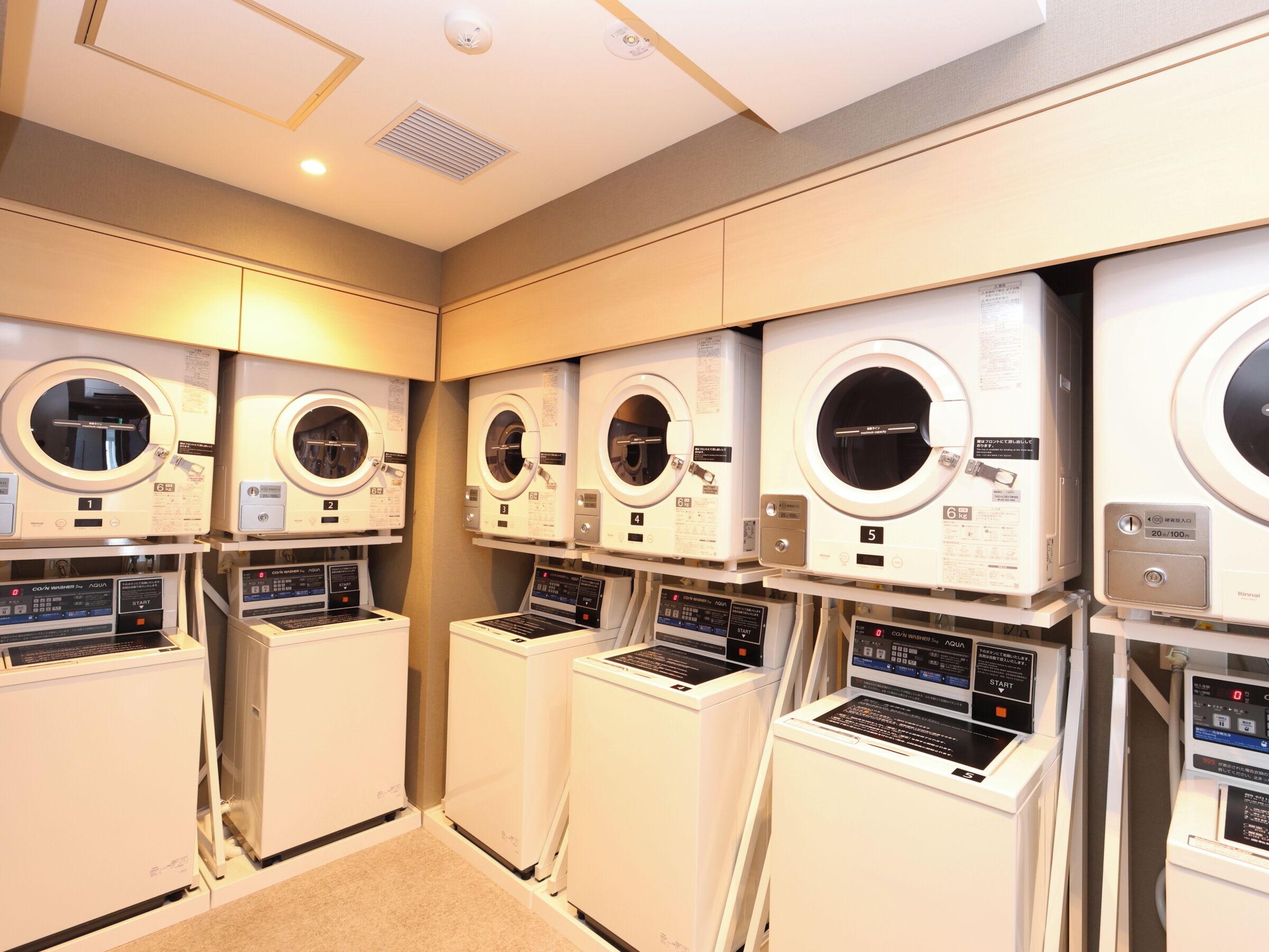A row of front-loading washing machines in a commercial setting.