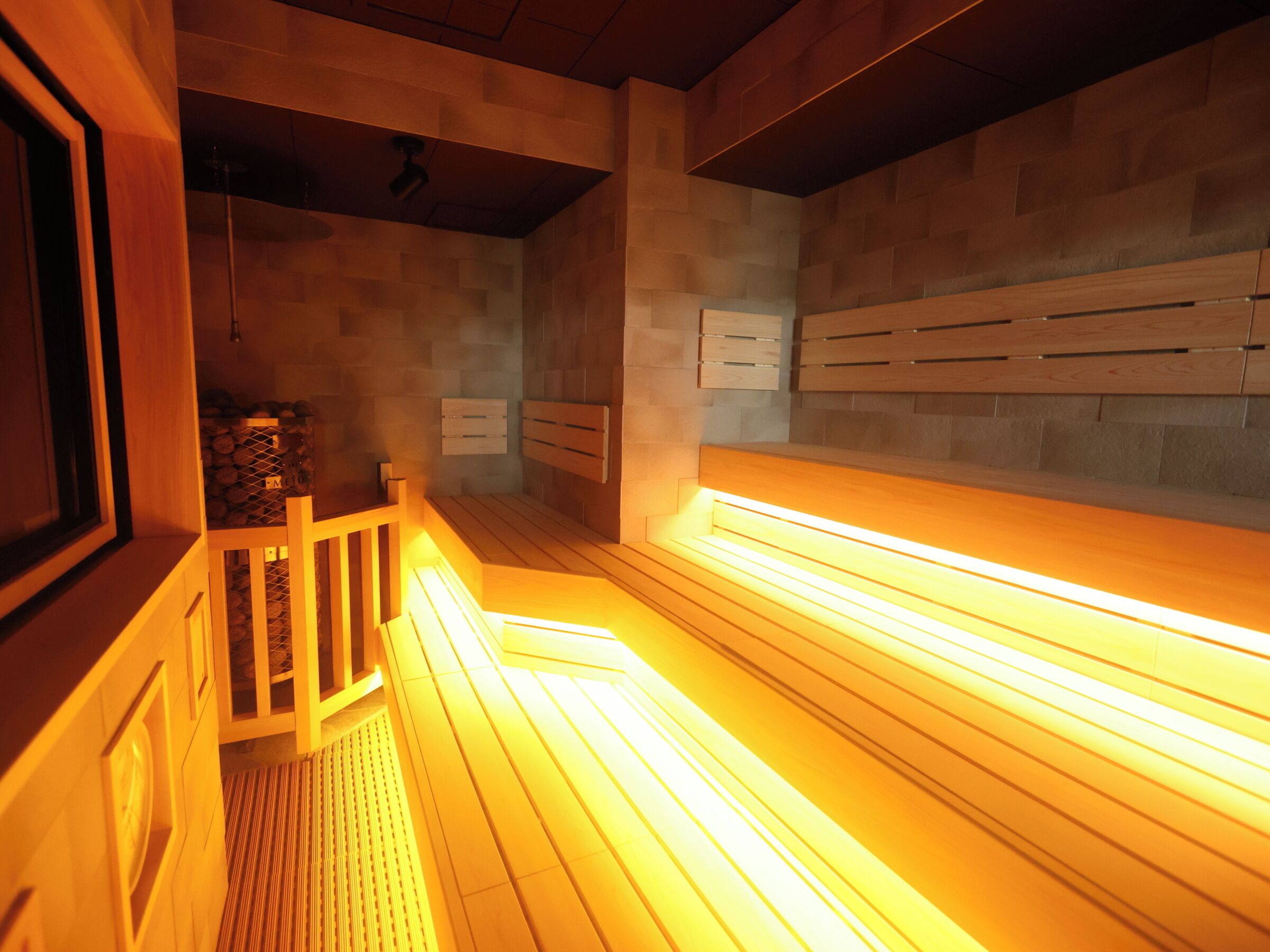 A sauna with wooden benches and a sloped ceiling.