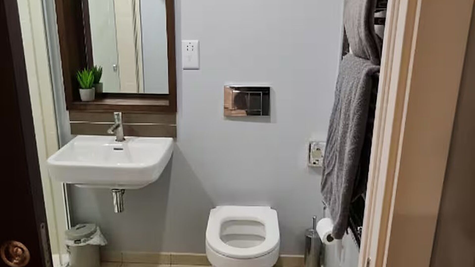 A bathroom with a white sink, a toilet, and a towel rack.