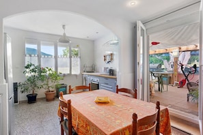A dining area with a table, chairs, and a potted plant.