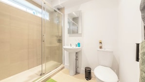 A modern bathroom with a glass shower enclosure, a pedestal sink, and a toilet. - Central - Stay 4 - Paid Parking - Near Transport (Maidstone)