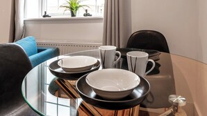 A dining table with black and white plates, a glass top, and a coffee mug. - Central - Stay 4 - Paid Parking - Near Transport (Maidstone)