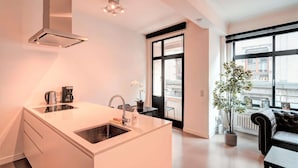 Una cocina moderna con una isla central, estufa integrada y ventana con vista a la ciudad.