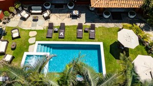 A large house with a tiled roof, a swimming pool, and outdoor seating. - Suri Búzios Hotel (Búzios)