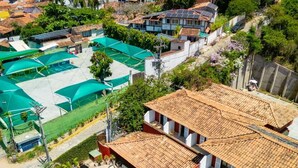A resort with a pool, outdoor seating, and a view of the sea. - Suri Búzios Hotel (Búzios)