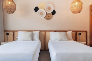 A hotel room with two beds, a woven headboard, and two wall-mounted lamps. - Modern 2BR Condo w/ Beach Views • Sol de Arena A6 (Las Terrenas)