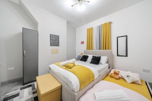 Une chambre d’hôtel moderne équipée d’un lit, de tables de chevet, d’une armoire et d’un escalier.