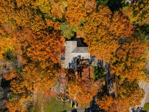 An aerial view of a building surrounded by autumn foliage.