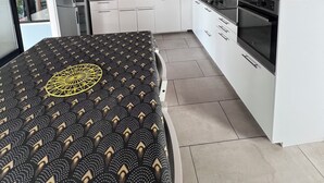 Een moderne keuken met witte kasten, een zwart aanrecht en een ingebouwde oven.