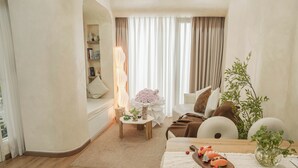 A cozy living room with a sofa, a table with decorative items, a lamp, and a plant. - Là Home - Stay Cozy, Stay Home Phú Nhuận (Ho Chi Minh City)