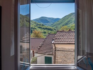 A window view of a mountainous landscape with traditional tiled roofs and stone buildings. - Rosano 76 - 5 minutes from Cabella Ligure (Rosano)