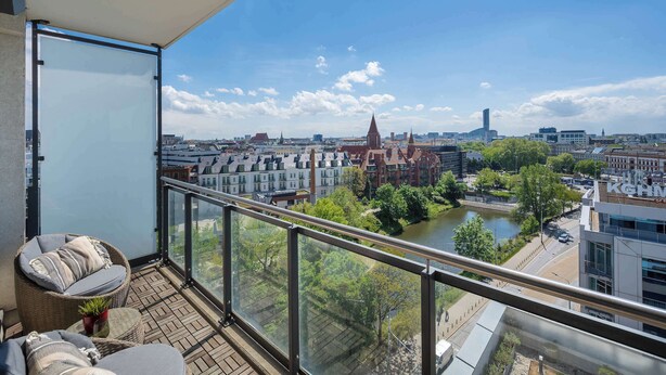 Un balcón con vista a un río, edificios y un puente.