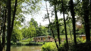 A cabin by a lake surrounded by trees. - Skylark (Ross-on-Wye)