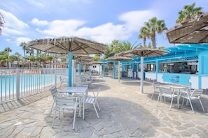 A poolside area with outdoor seating, umbrellas, and a bar. - Oasis Duna _ Estrella Del Mar Pool with Shared Pool, Private Terrace, and Wi-Fi (Corralejo)