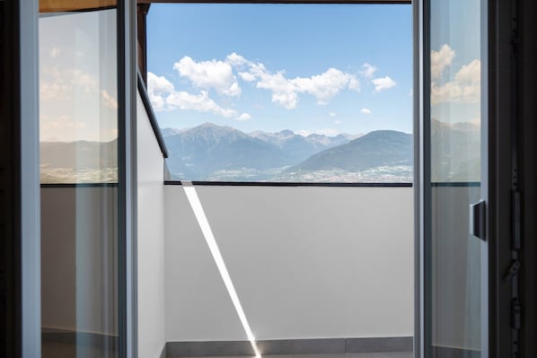 A room with a large window offering a mountain view.