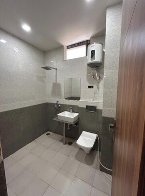 Un baño con ducha, lavamanos e inodoro.