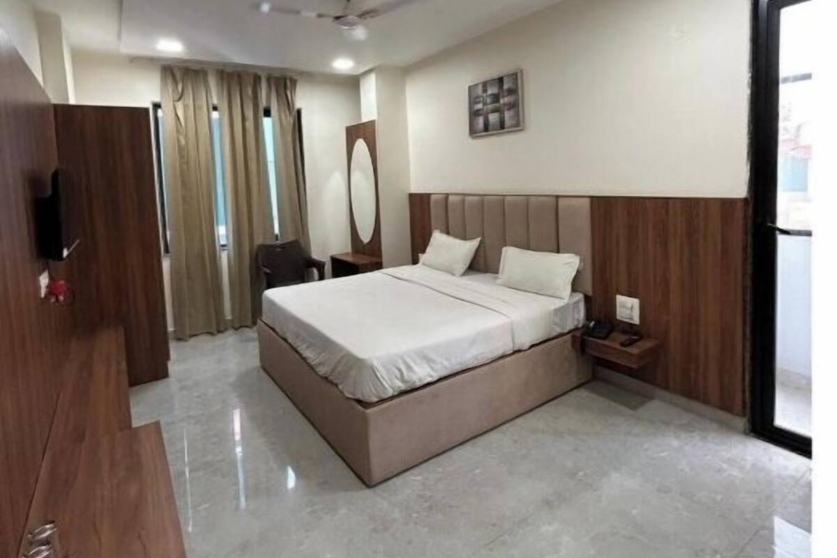 Una habitación de hotel moderna con una cama grande, un escritorio, un armario y un ventilador de techo.