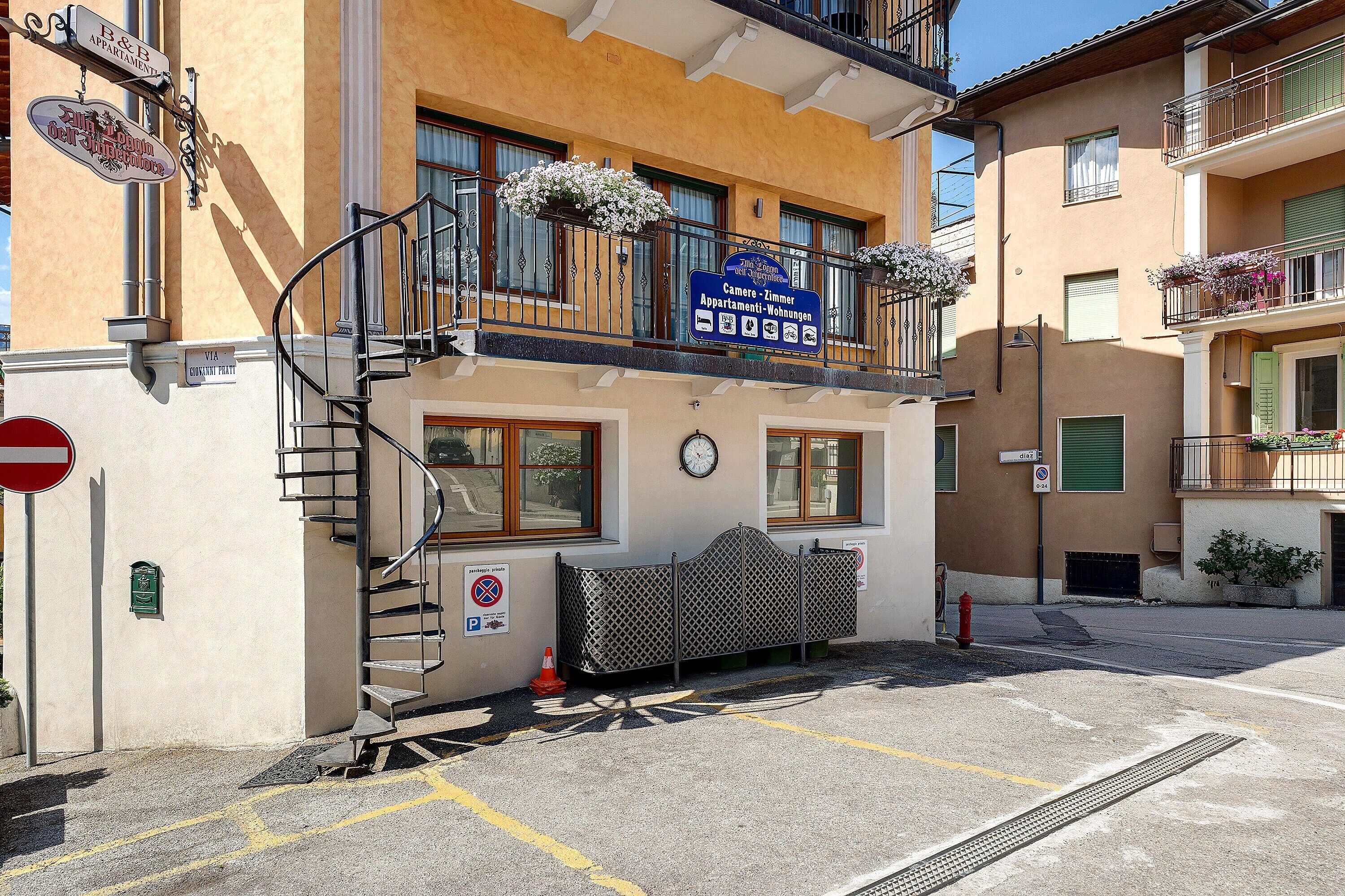 Un immeuble avec une enseigne indiquant « Camera – Appartements Immer » et un escalier menant à un balcon.