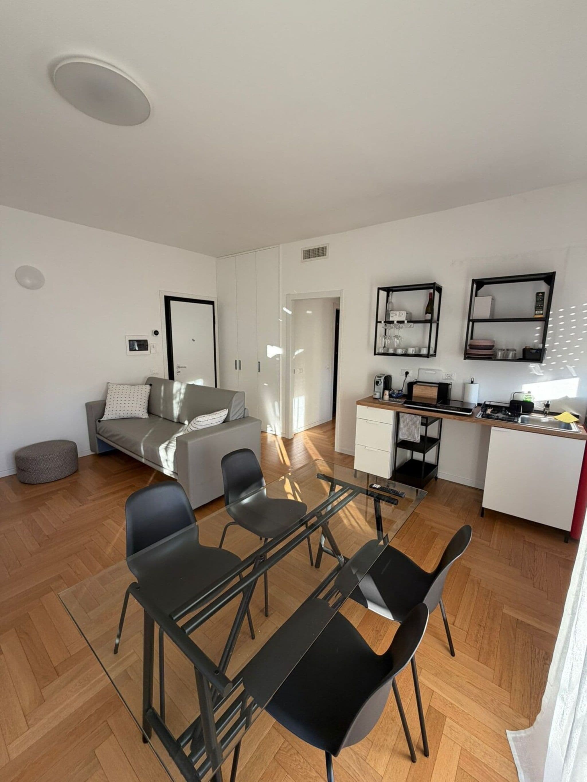 A modern apartment with a dining area, kitchenette, and a living space with a sofa and a coffee table.