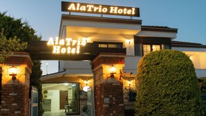 The AlaTrio Hotel entrance with a sign, a brick entrance, and a well-lit pathway. - Alatrio Hotel Alaçatı (Cesme)