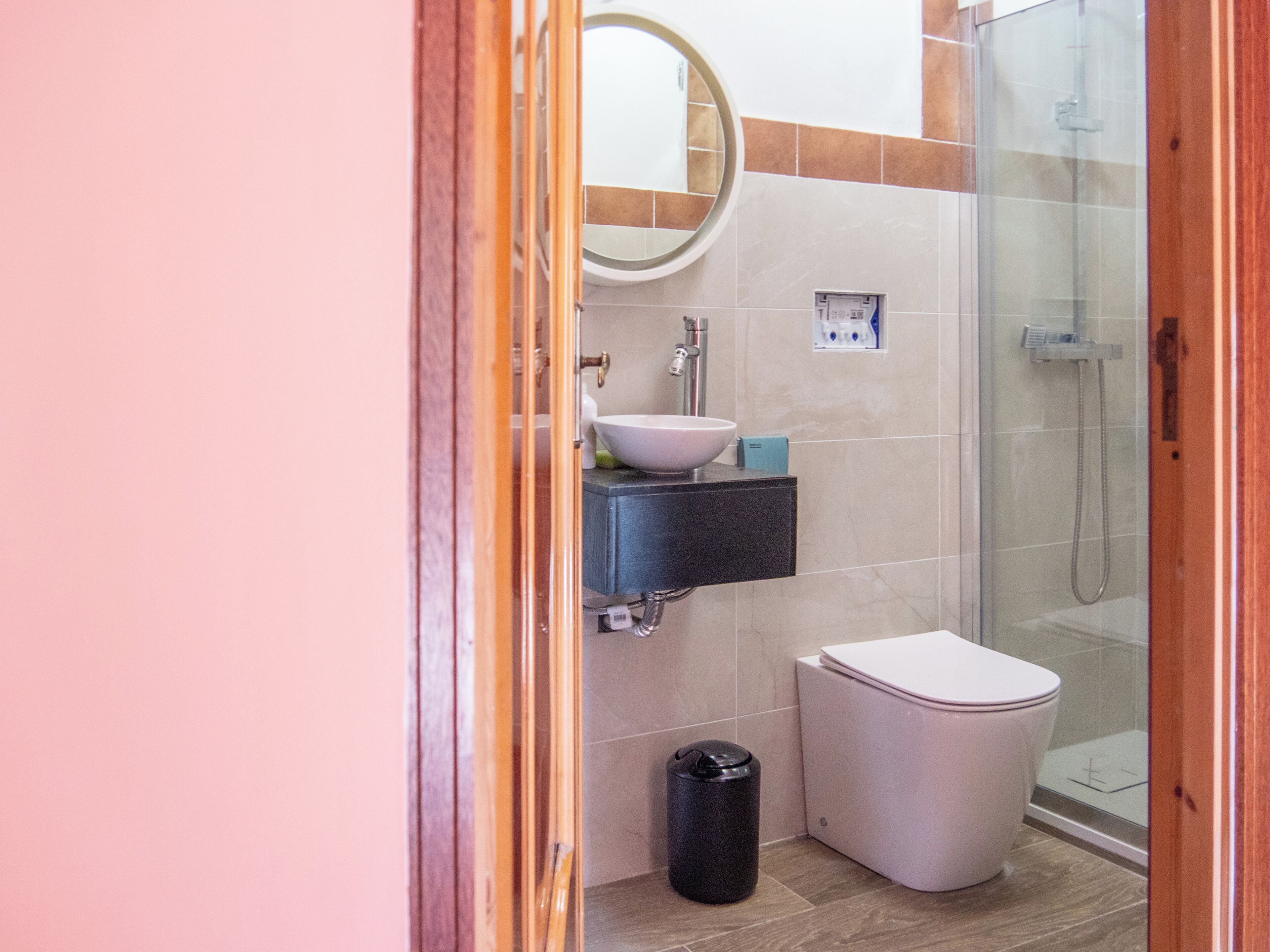 A bathroom with a toilet, sink, and shower.
