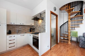 A modern kitchen with white cabinets, a stone backsplash, and a built-in oven. - Vivienne In Front Of Pool Holiday Home with Shared Pool, Wi-Fi & Air Conditioning (Desenzano del Garda)