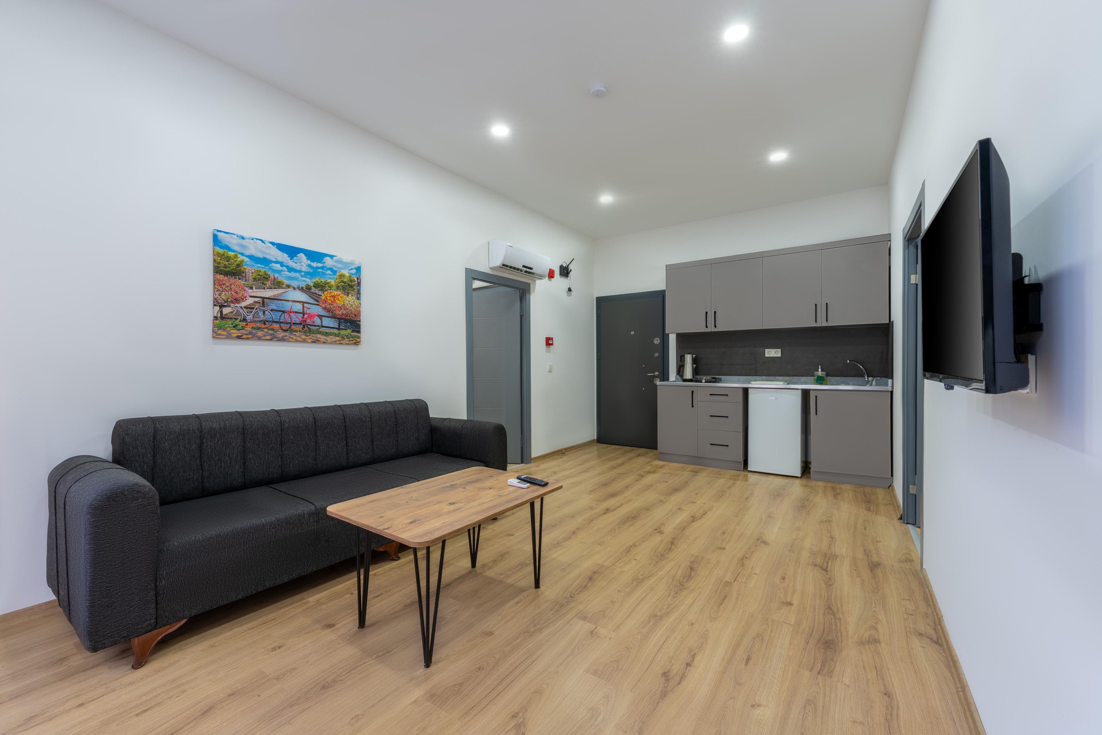 Een moderne zithoek met een bank, salontafel en schilderij aan de muur.