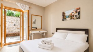 Ein Schlafzimmer mit Bett, Schreibtisch, Stuhl, Fenster und einem Bild.
