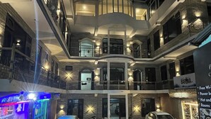 A multi-story building with balconies, a bar, and a sign indicating free Wi-Fi and power outlets. - Narayan Guest House Kasol (Kasol)
