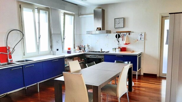 Una cocina moderna con una mesa de comedor, sillas y una ventana.