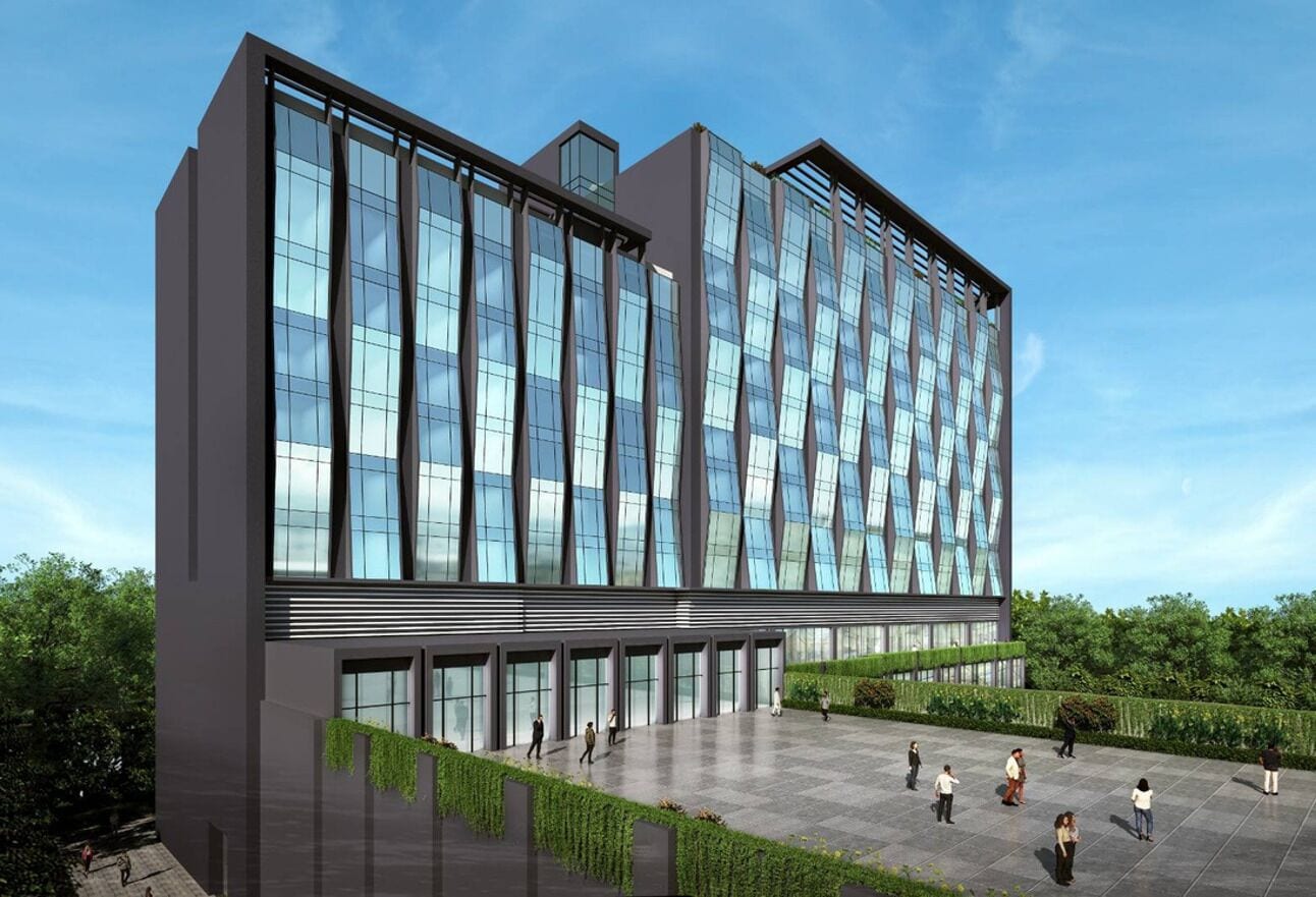 A modern building with a glass facade, a flat roof, and a paved courtyard with people walking.