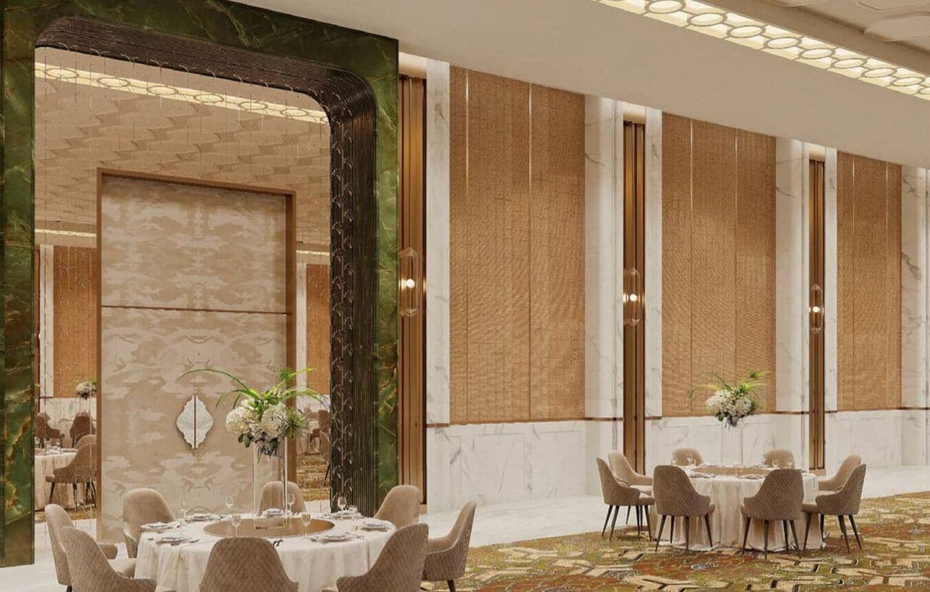 A hotel dining area with round tables and chairs, a patterned carpet, and decorative wall panels.