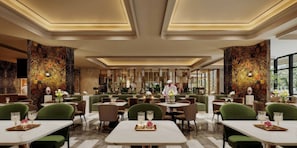 A restaurant with multiple dining tables and chairs, a chef preparing food, and decorative wall panels.