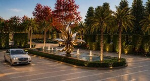 A parking lot with a fountain and palm trees. - Altara Indore (Indore)