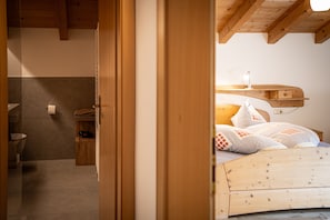 Ein Schlafzimmer mit einem hölzernen Kopfende, einem Nachttisch und einem Beistelltisch.
