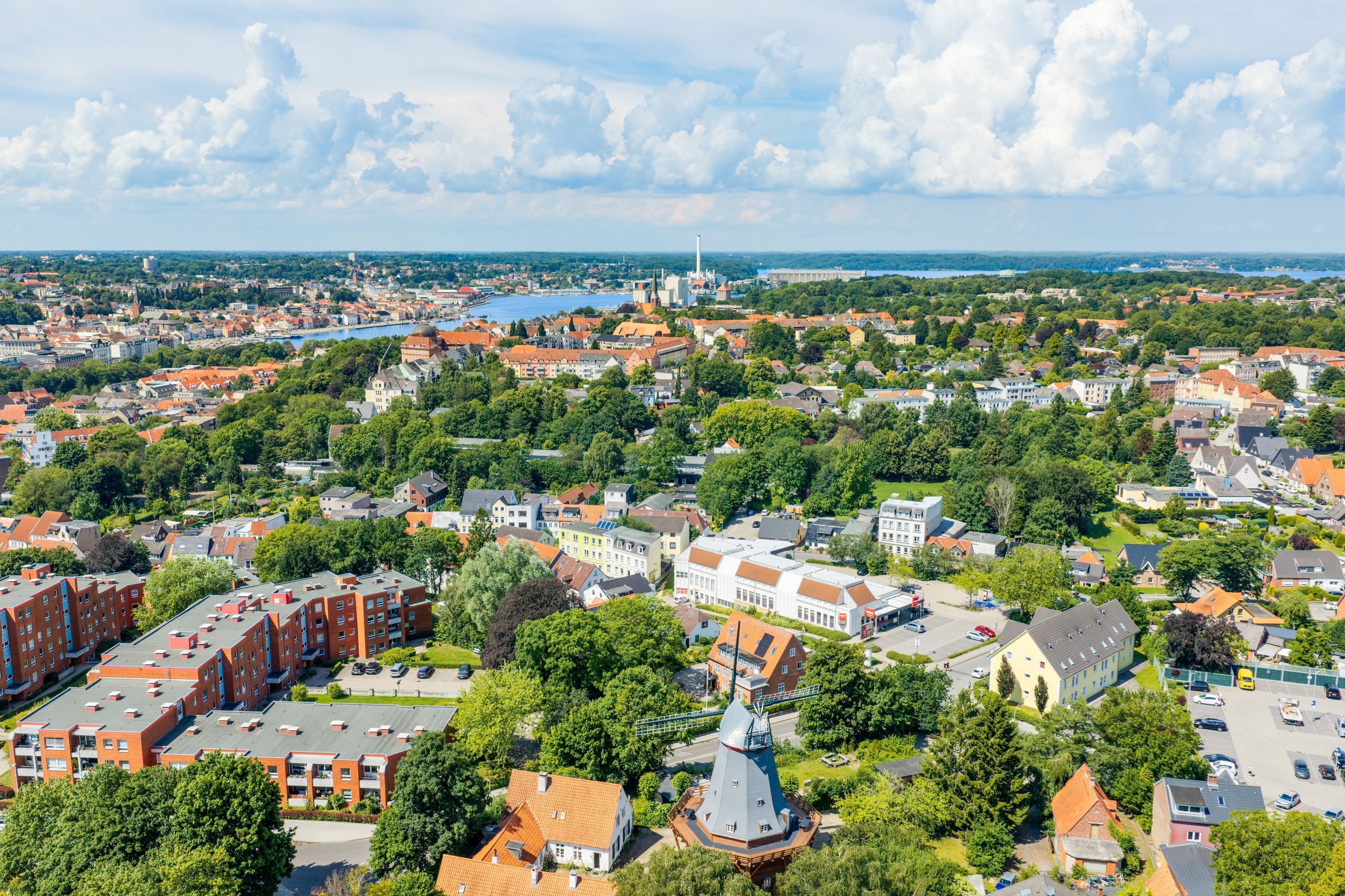 A cityscape with a mix of residential and commercial buildings, a prominent church, and a river.
