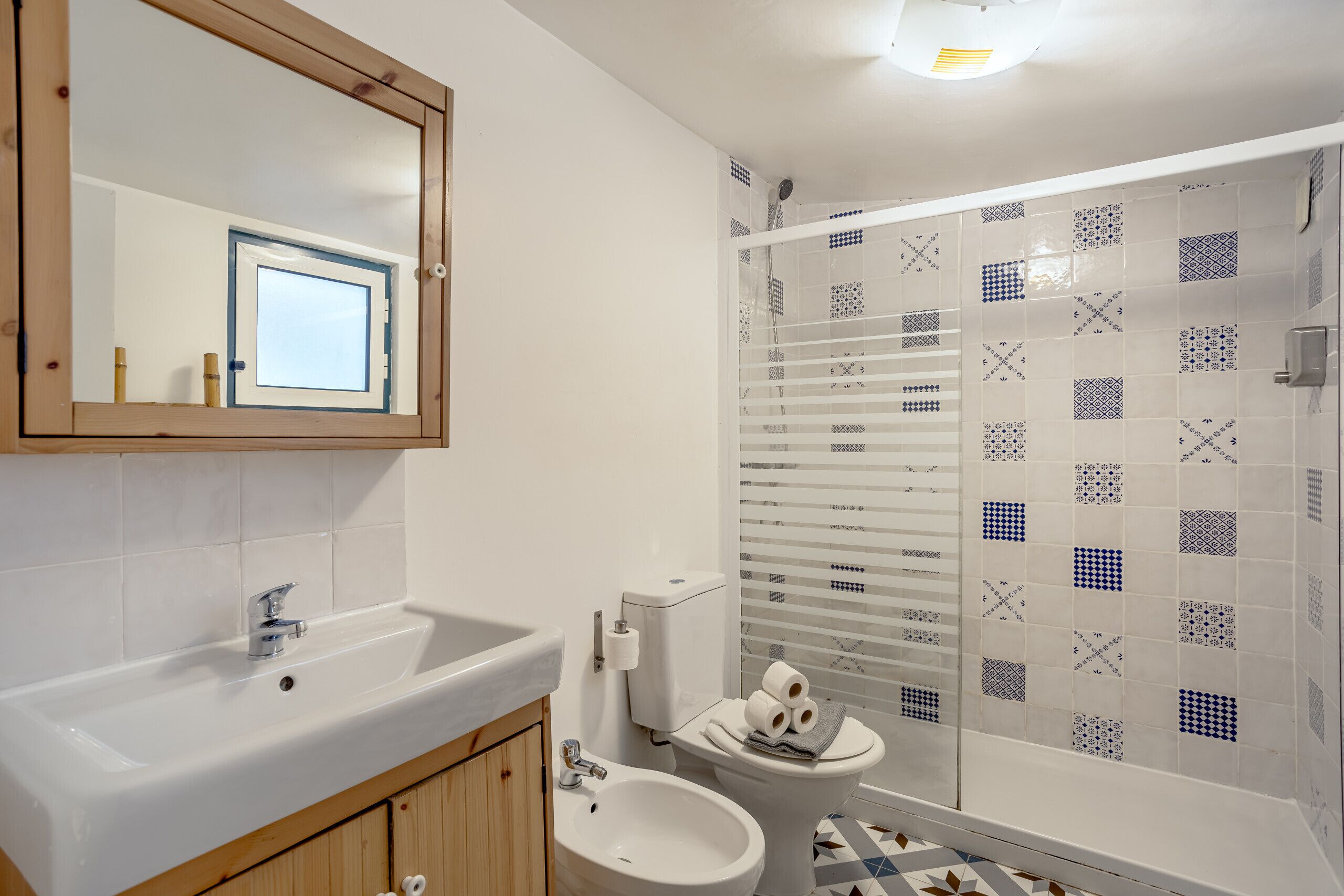Un baño con lavamanos, bidé, inodoro y ducha.