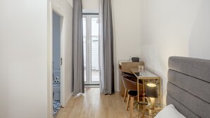A room with a bed, a desk, a chair, a lamp, and a window with curtains. - Boavista 130 Studios I by Homing (Lisbon)