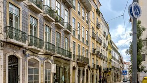 Uma fileira de edifícios históricos com varandas elaboradas e grandes janelas.