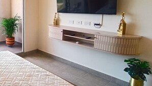 A modern bedroom with a large bed, a mounted TV, and built-in storage. - Luxury Apartment Suite With Ocean Views and Swimming Pools! (Santa Marta)