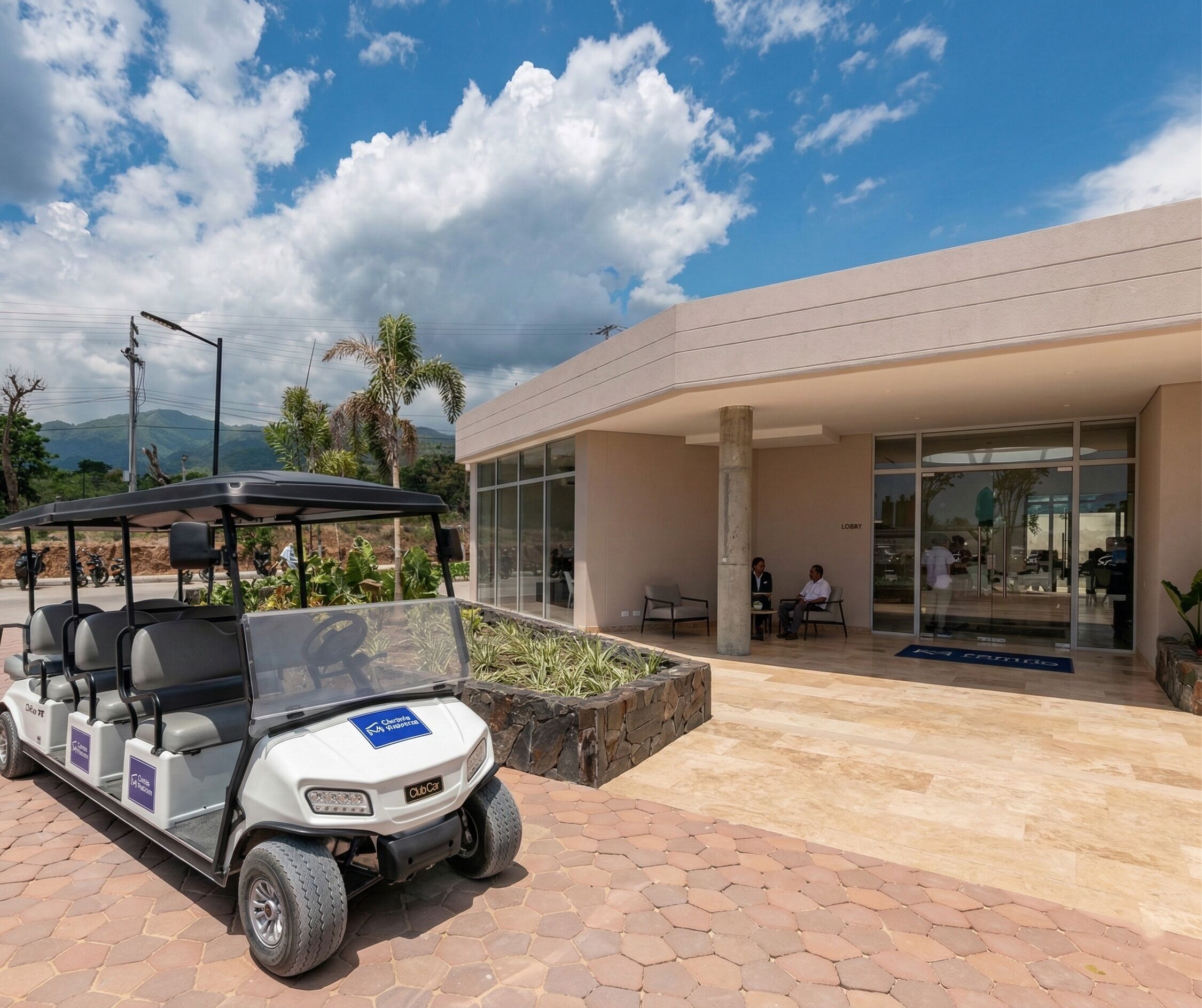 A modern building with a glass entrance, a golf cart, and a landscaped area with plants.