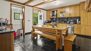 Una cocina moderna con armarios de madera, una isla central y un comedor con bancos.